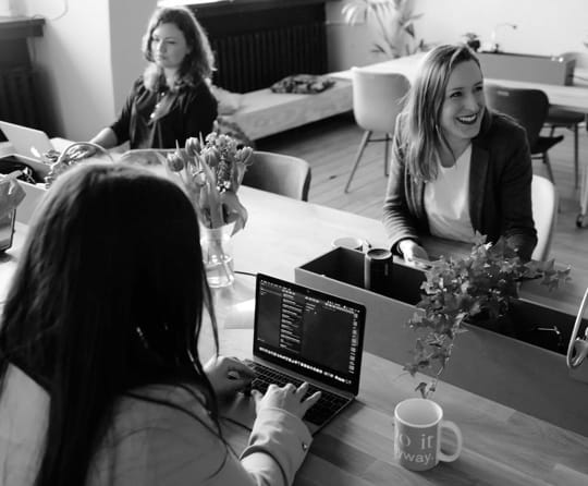 A random image of women working with computers and laughing